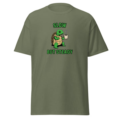 The FunnyDripStore Slow But Steady T-Shirt is a black tee with a cartoon turtle holding a coffee mug and SLOW above and BUT STEADY below in green—perfect meme shirt for coffee lovers.