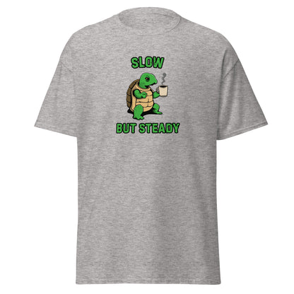 The FunnyDripStore Slow But Steady T-Shirt is a black tee with a cartoon turtle holding a coffee mug and SLOW above and BUT STEADY below in green—perfect meme shirt for coffee lovers.