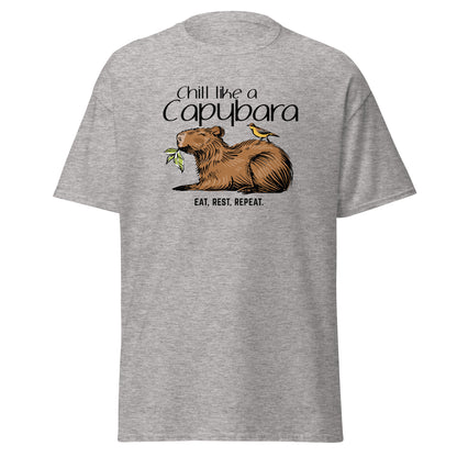 Chill Like A Capybara T-Shirt by FunnyDripStore: White tee with a relaxed capybara and bird eating a leaf, captioned “Chill like a Capybara” above and “Eat, rest, repeat” below. Perfect funny shirt for laid-back meme lovers!.