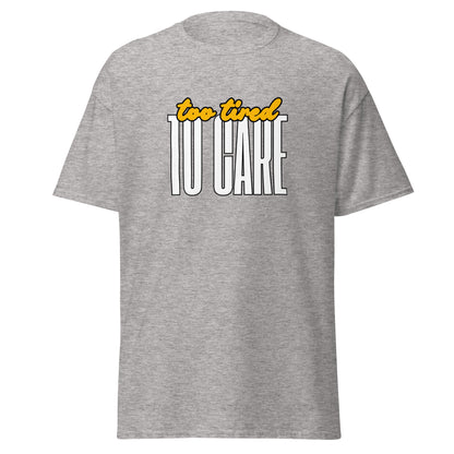 The FunnyDripStore Too Tired To Care T-Shirt in charcoal features too tired in yellow cursive above bold white TO CARE, making this meme shirt funny and ideal for relaxed days.